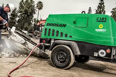 A man using an air compressor from Sunbelt Rentals.