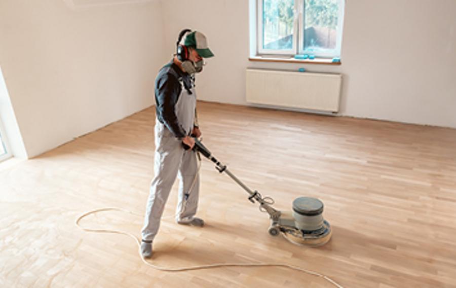 Someone sanding a hardwood floor.