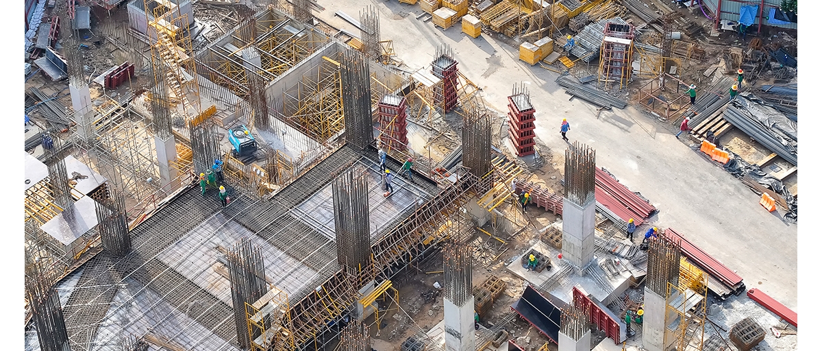 Cement and rebar pilings jut out of the ground on a construction work site.