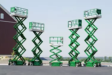 Five scissor lifts from Sunbelt Rentals raised to various heights.