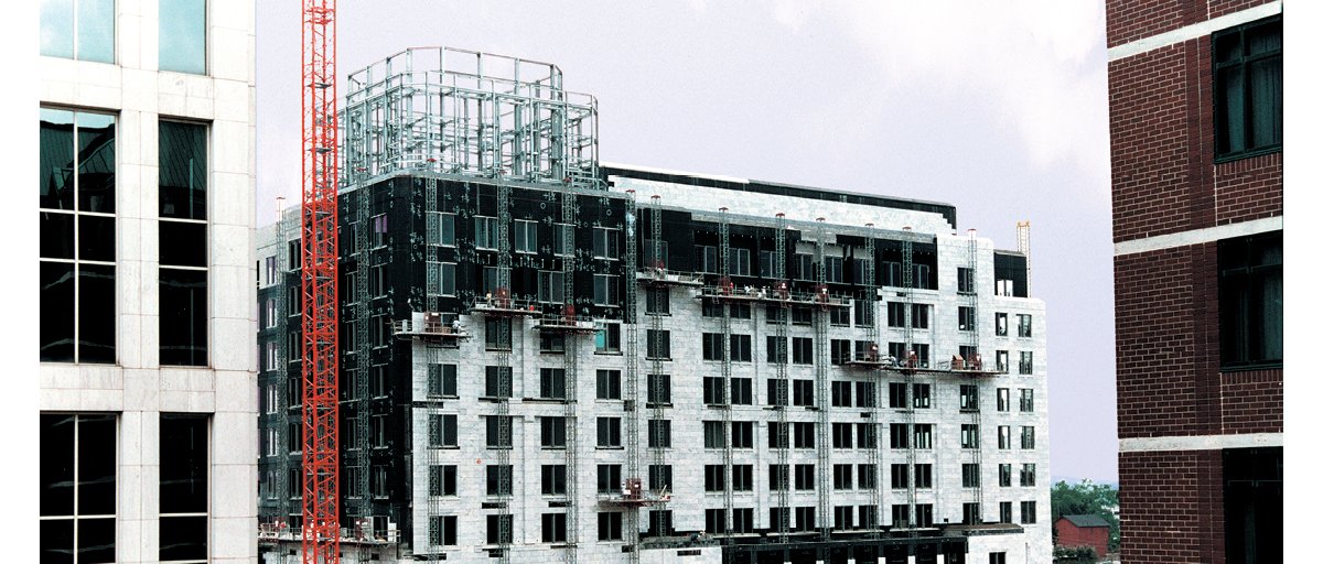 Mast climbing work platforms in use on a building.