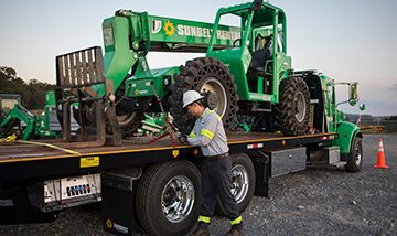 Sunbelt Rentals worker strapping in Telehandler for transport