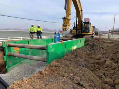 Two Sunbelt Rentals workers standing next to a trench box on a jobsite. 