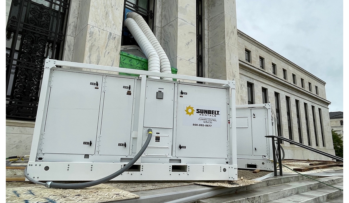Large commercial air conditioning units positioned outside of a government building with marble walls and steps.