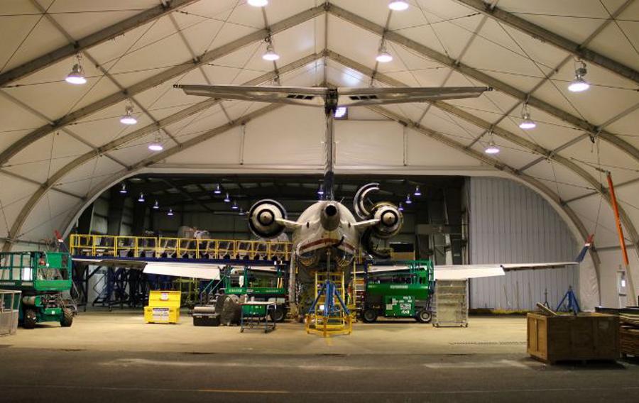 Airplane in a hangar surrounded by green Sunbelt Rentals equipment.