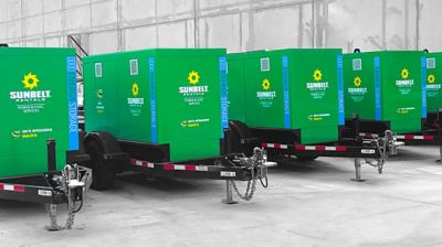 Battery energy storage systems lined up outside of a building.