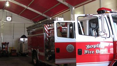 A fire truck parked inside of a temporary structure.