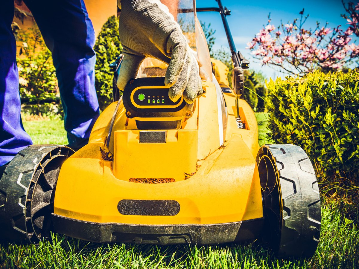 Someone checking the battery level on a battery mower screen.