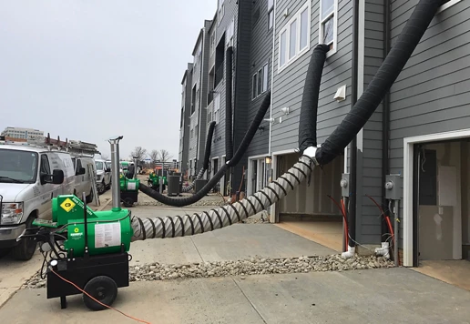 Portable industrial heaters from Sunbelt Rentals outside of a residential building. 