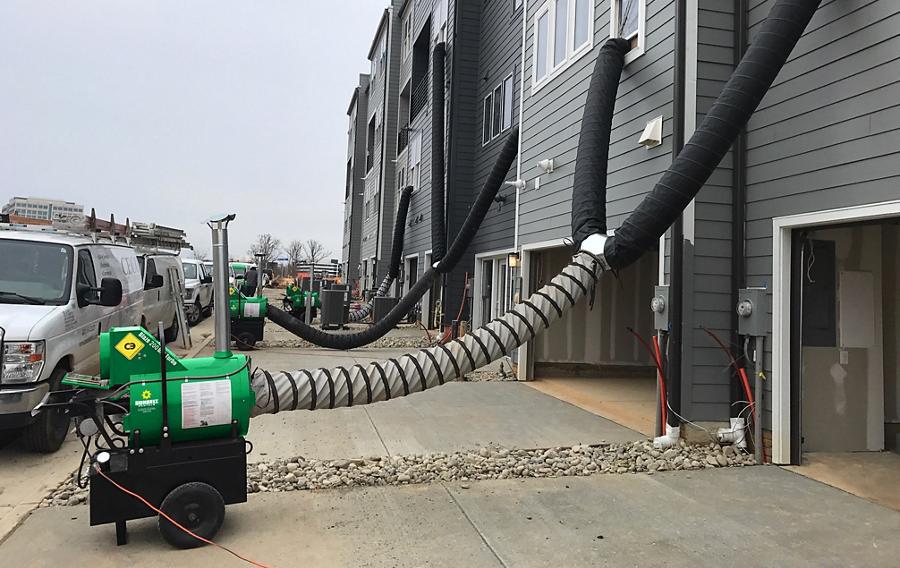 Portable industrial heaters from Sunbelt Rentals outside of a residential building. 