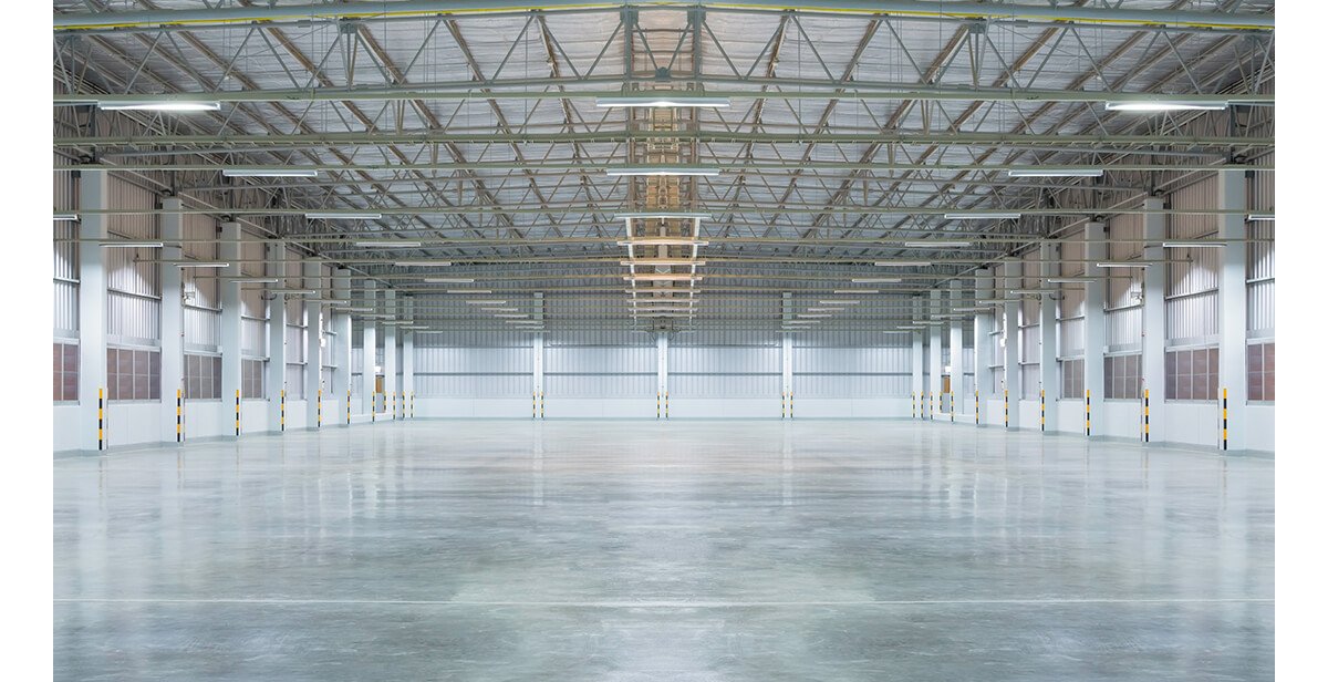 The inside of an open building with concrete flooring.