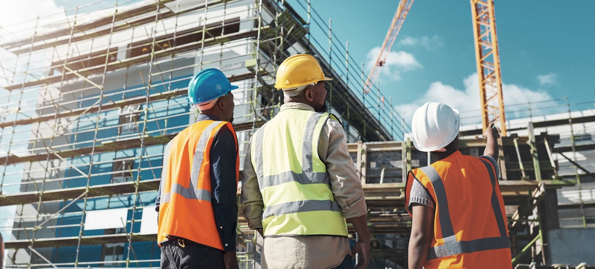 Shot of a group of builders assessing progress at a construction site