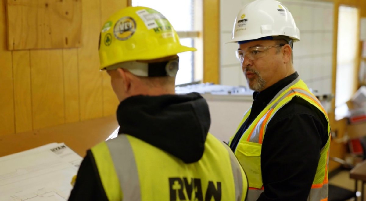 Two people wearing safety apparel working on heat estimation.