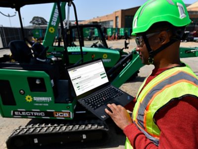 Someone at a job site using the Sunbelt Rentals Delivery Tracker on their laptop computer.