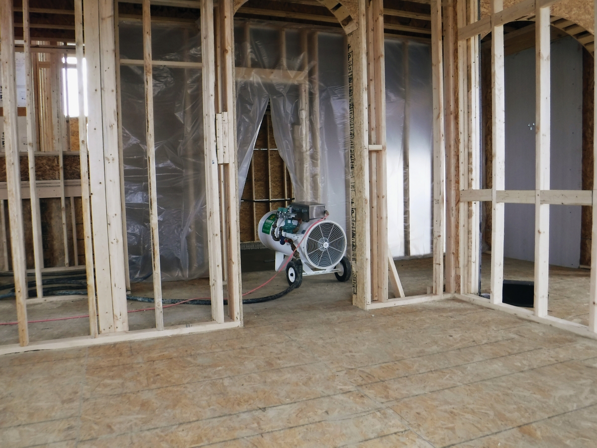 A direct-fired torpedo heater from Sunbelt Rentals at a home construction site.