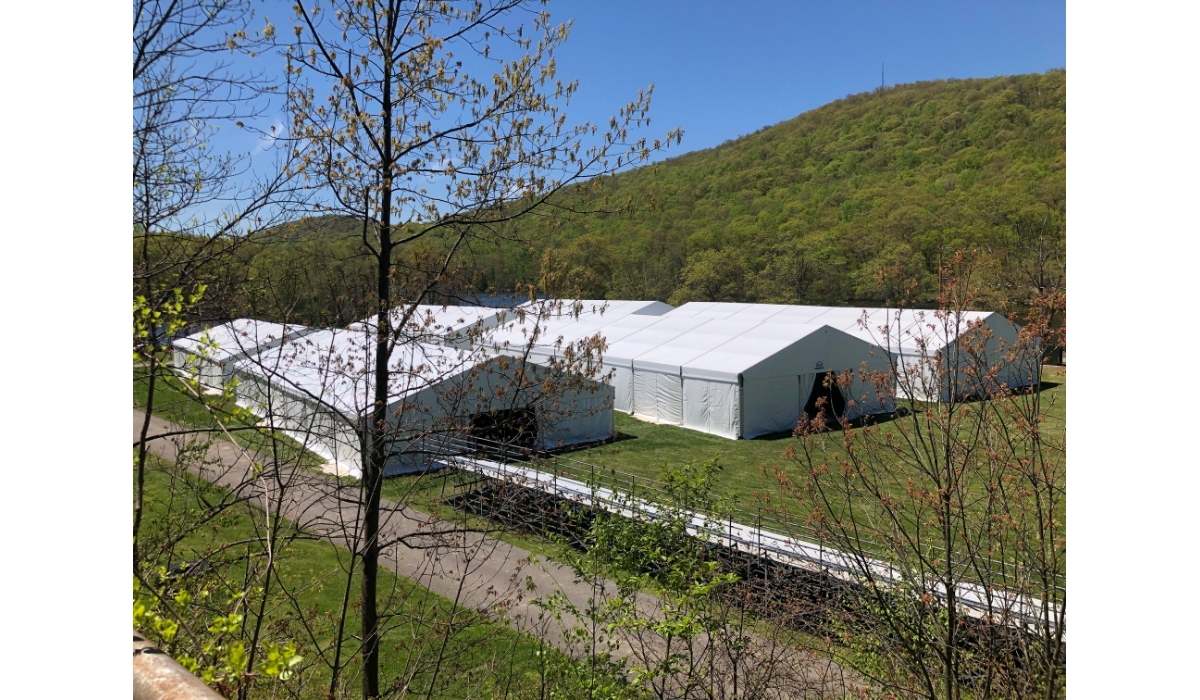 Temporary structures set up near hills.
