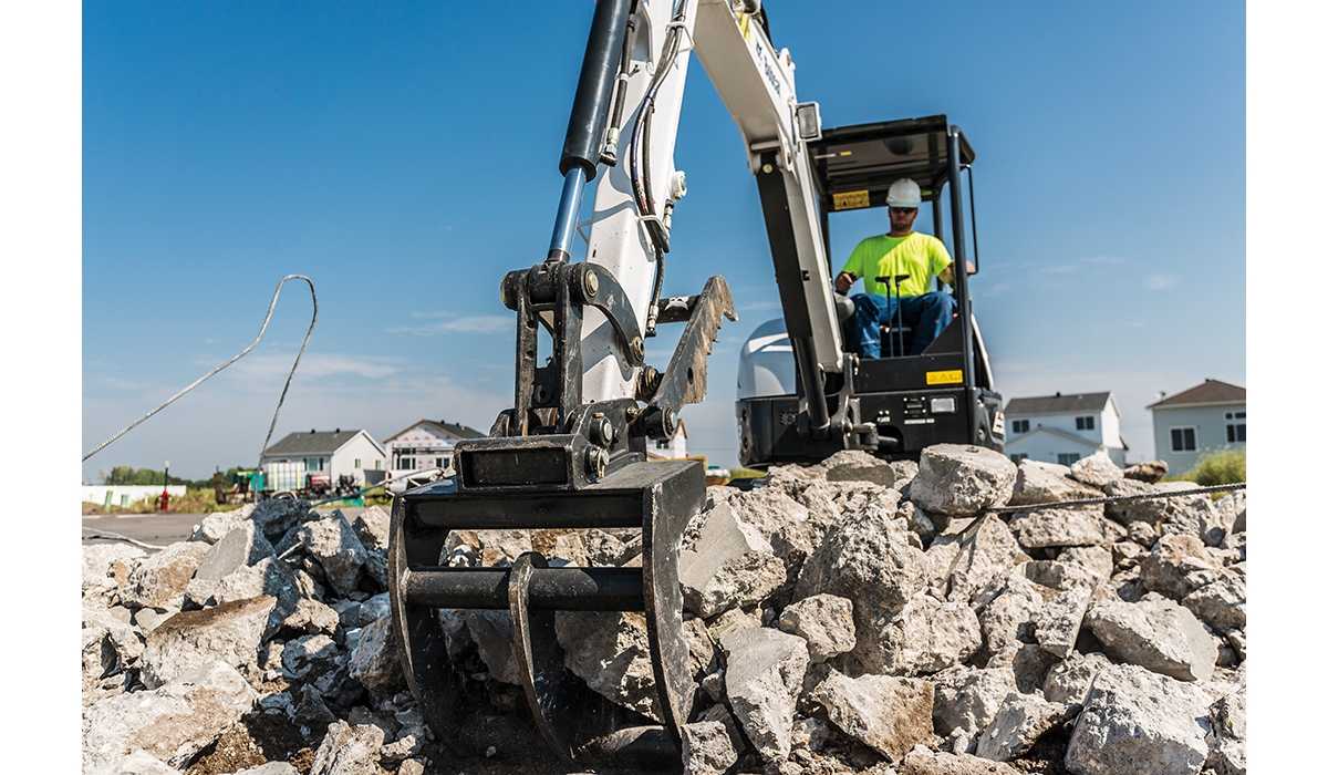 An excavator moving rocks at a job site.