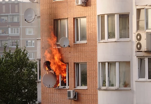 Fire coming outside of the window from a residential building.