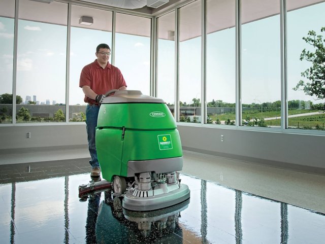 Someone operating a floor scrubber.