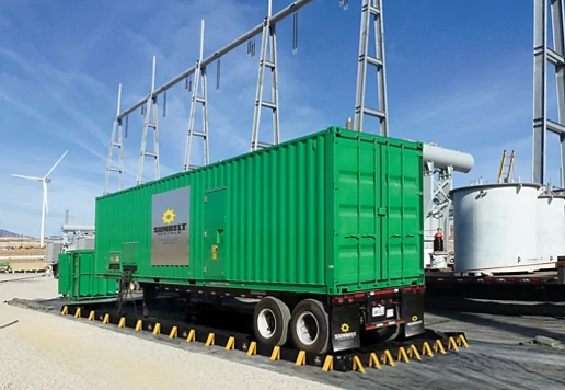 A generator near wind turbines in an industrial area.
