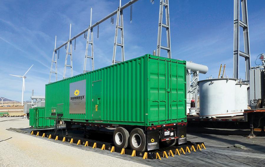 A generator near wind turbines in an industrial area.