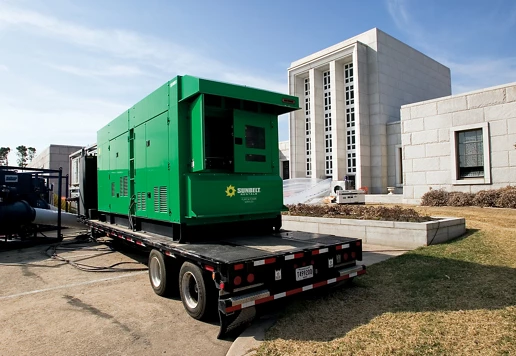 A generator from Sunbelt Rentals on a trailer, installed outside of a building.