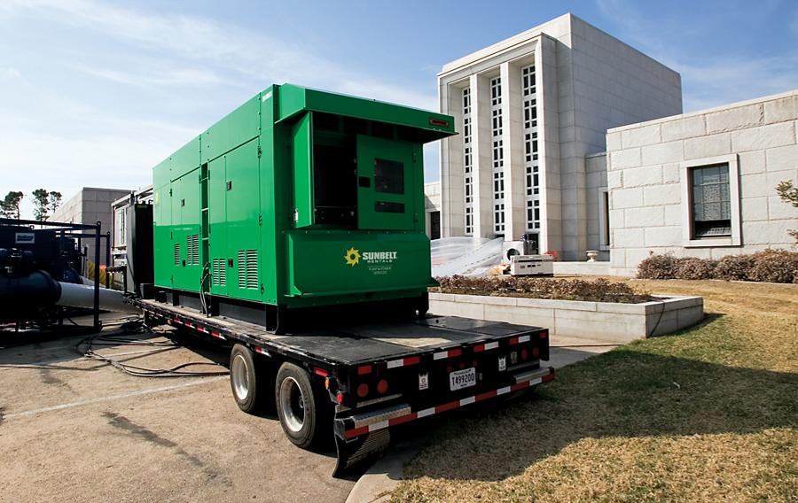 A generator from Sunbelt Rentals on a trailer, installed outside of a building.