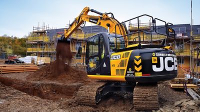 A hydraulic excavator moving dirt at a construction site.