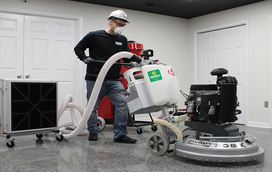 Person using surface preparation equipment on flooring.