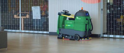 A robotic floor cleaner sitting in a commercial space.