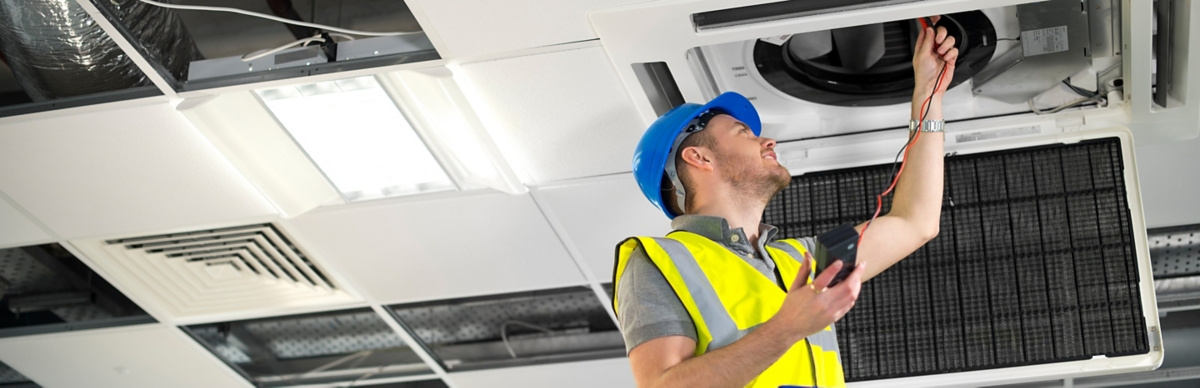 electrician fitting air conditioning to office interior