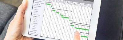 Someone holding a tablet device showing a project schedule.