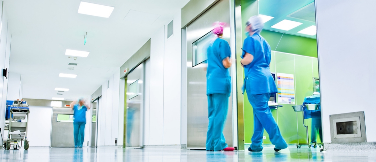 People standing in the hallway of a healthcare facility.