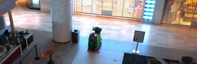 A robotic floor cleaner sitting inside of a shopping mall.