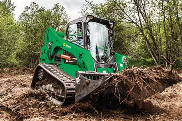 A Sunbelt Rentals backhoe using a rock bucket attachment.