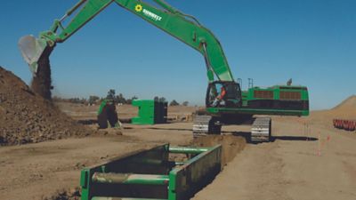 Someone driving an excavator to dig at a construction site.