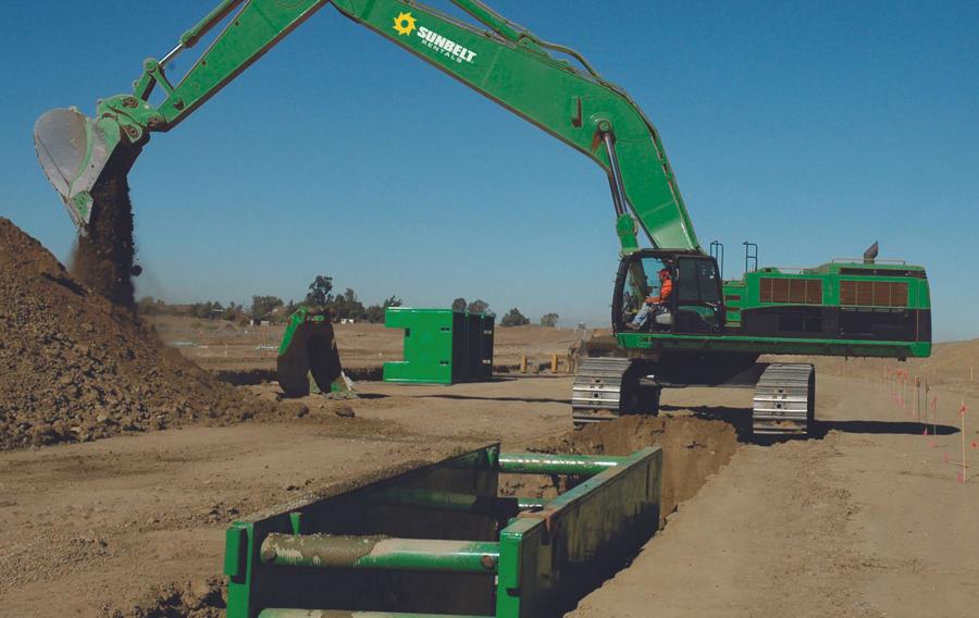 Someone driving an excavator to dig at a construction site.