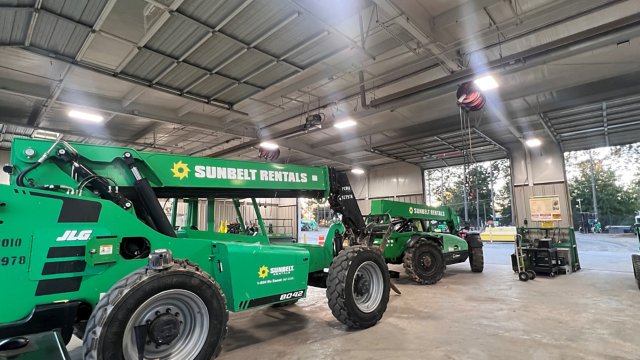 Sunbelt Rentals telehandlers and lifts being used in a warehouse. 