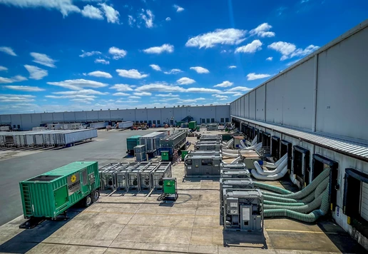 Chillers and generators outside of a large industrial building.