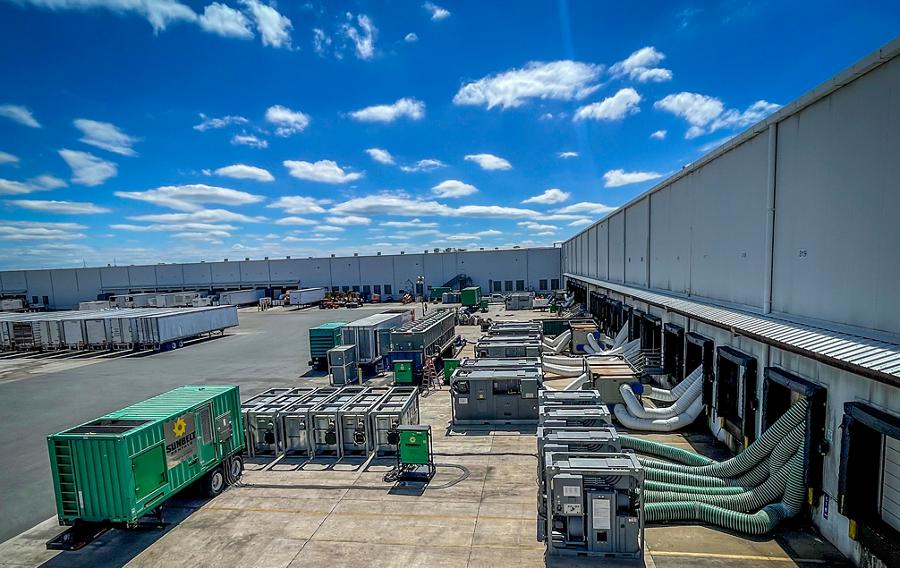 Chillers and generators outside of a large industrial building.