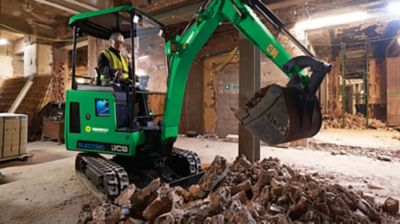 A mini excavator in a building under construction.