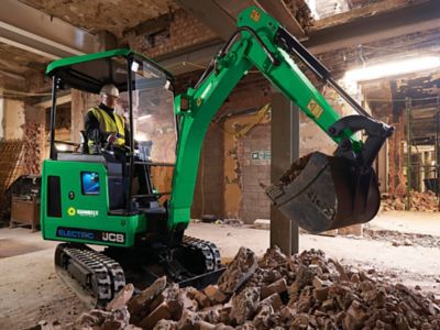 A mini excavator in a building under construction.