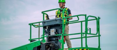 Someone wearing safety apparel operating a mobile elevating work platform.