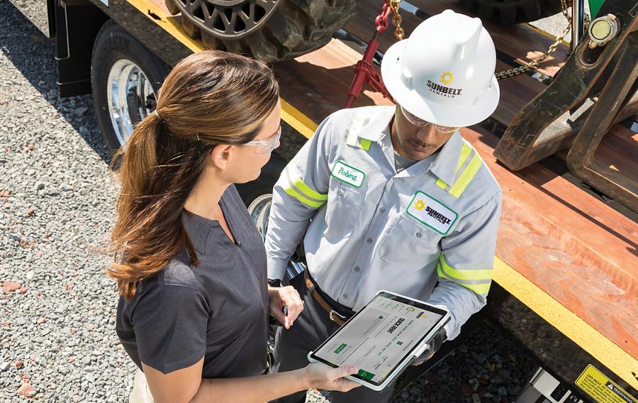 People reviewing a tablet device at a job site.
