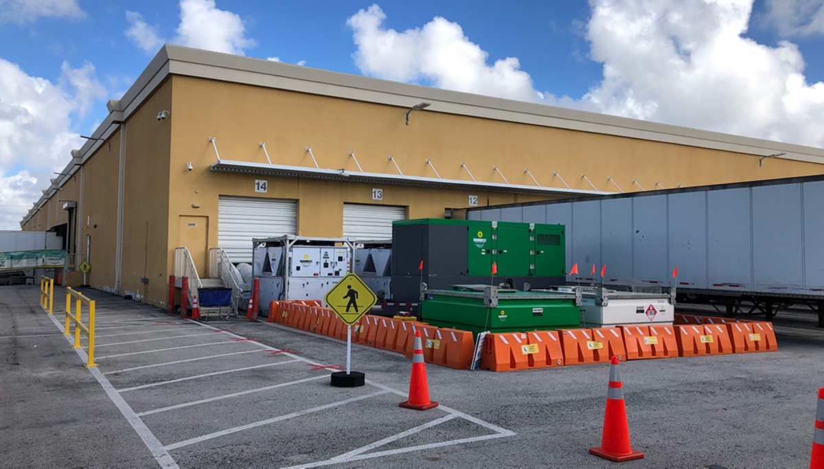 Rental HVAC equipment from Sunbelt Rentals, outside of a loading dock with garage doors and safety barriers.