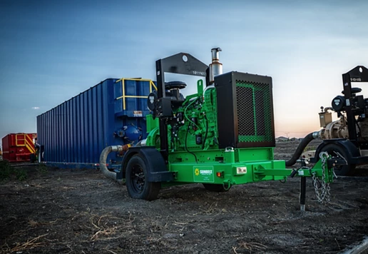 A high head pump from Sunbelt Rentals on a dirt lot, alongside other equipment.