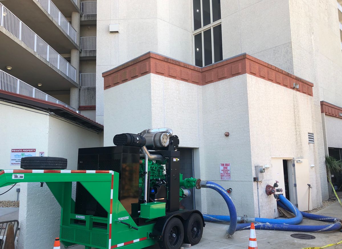 A high head pump installed outside of a tall, multi-story building.