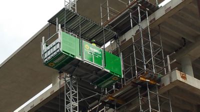 A Sunbelt Rentals worker on scaffolding at a job site.