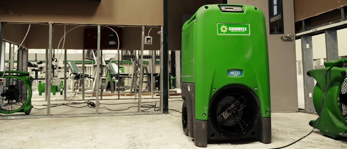 A refrigerant dehumidifier and an open air fan inside of a commercial building.