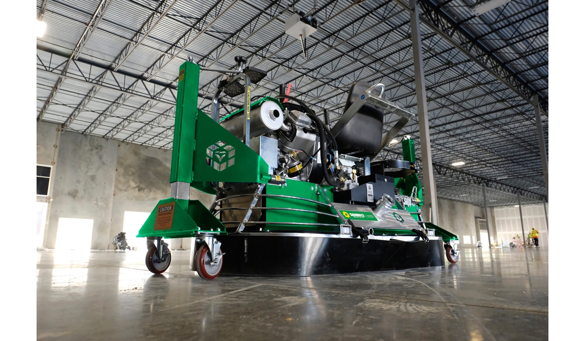 A ride on polishing trowel from Sunbelt Rentals inside of an empty warehouse building.